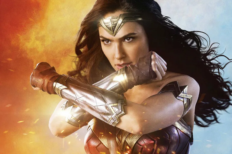 Actress Gal Gadot as Wonder Woman holding her armoured arms in a cross in front of her chest